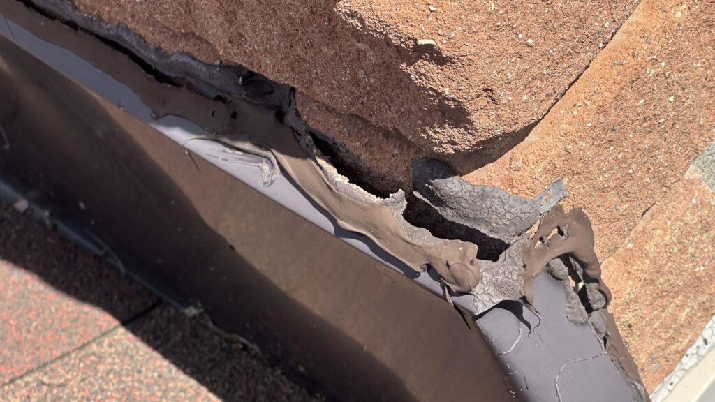 Broken caulking and open gap between chimney bricks and flashing that can allow bats into a home