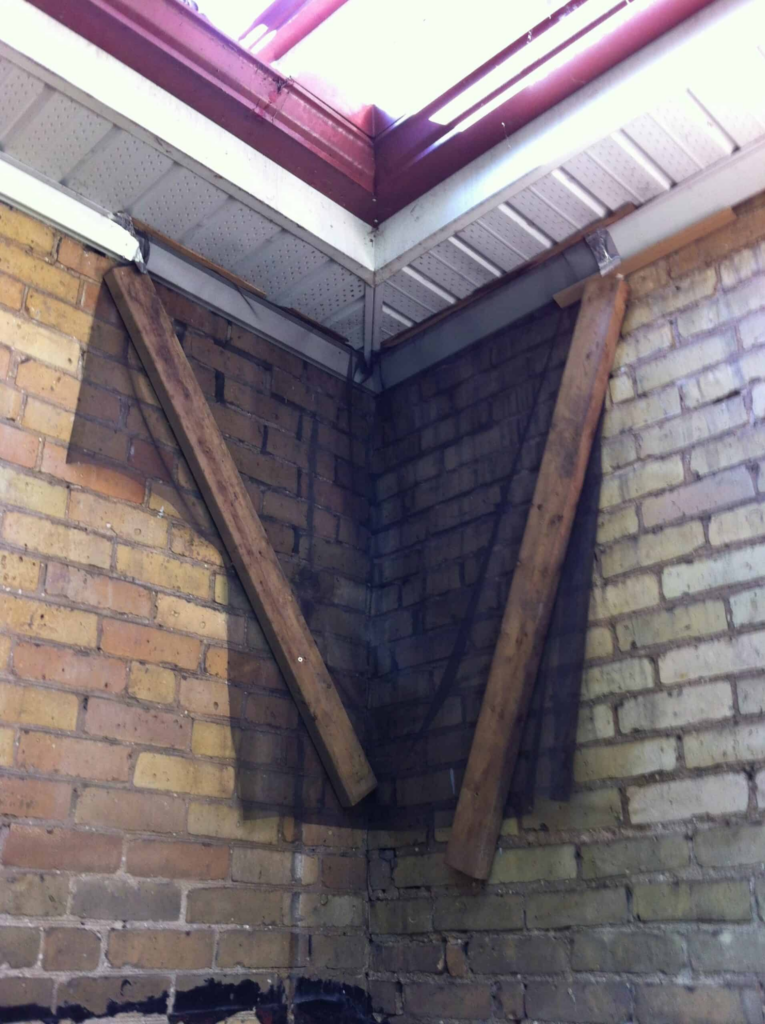 Homemade bug screen draped over brick and soffit areas as a failed bat exclusion attempt