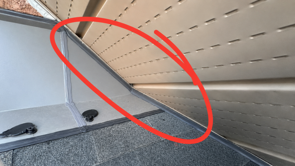 After photo of gap between aluminum soffit, shingles, and roof flashing sealed to prevent bat entry.