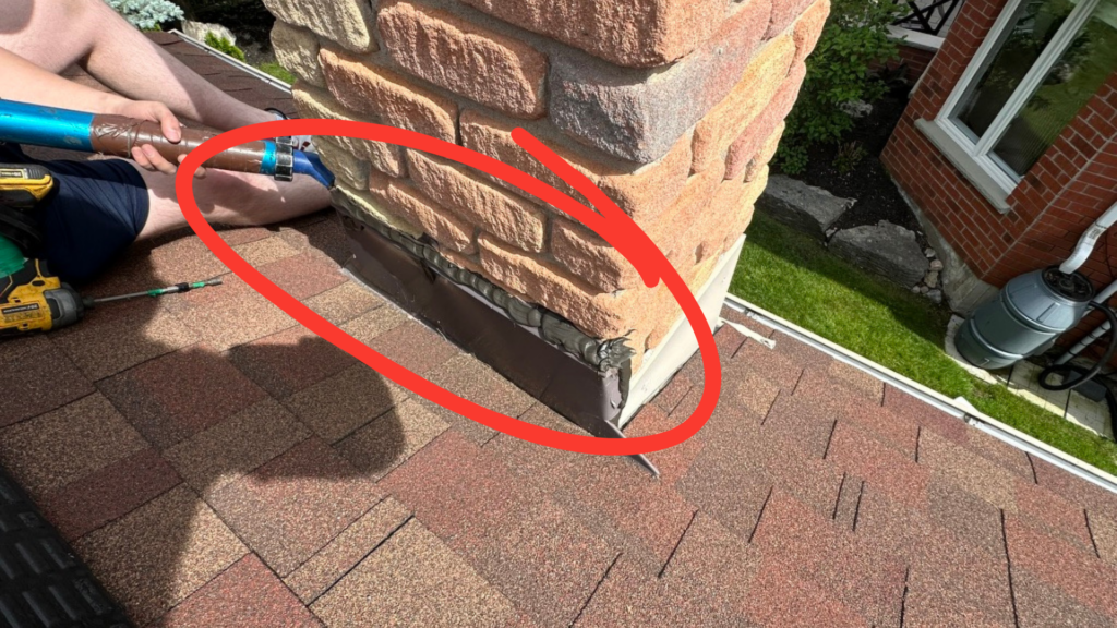 Saddle flashing at the back of a brick chimney with the top edge caulked