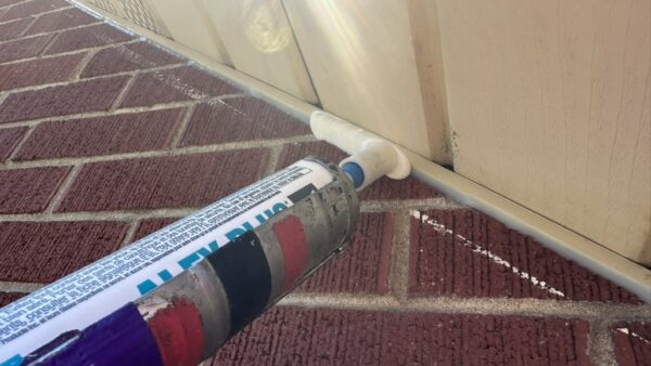 Wide bead of exterior caulking applied to seal a gap between the soffit and brick wall